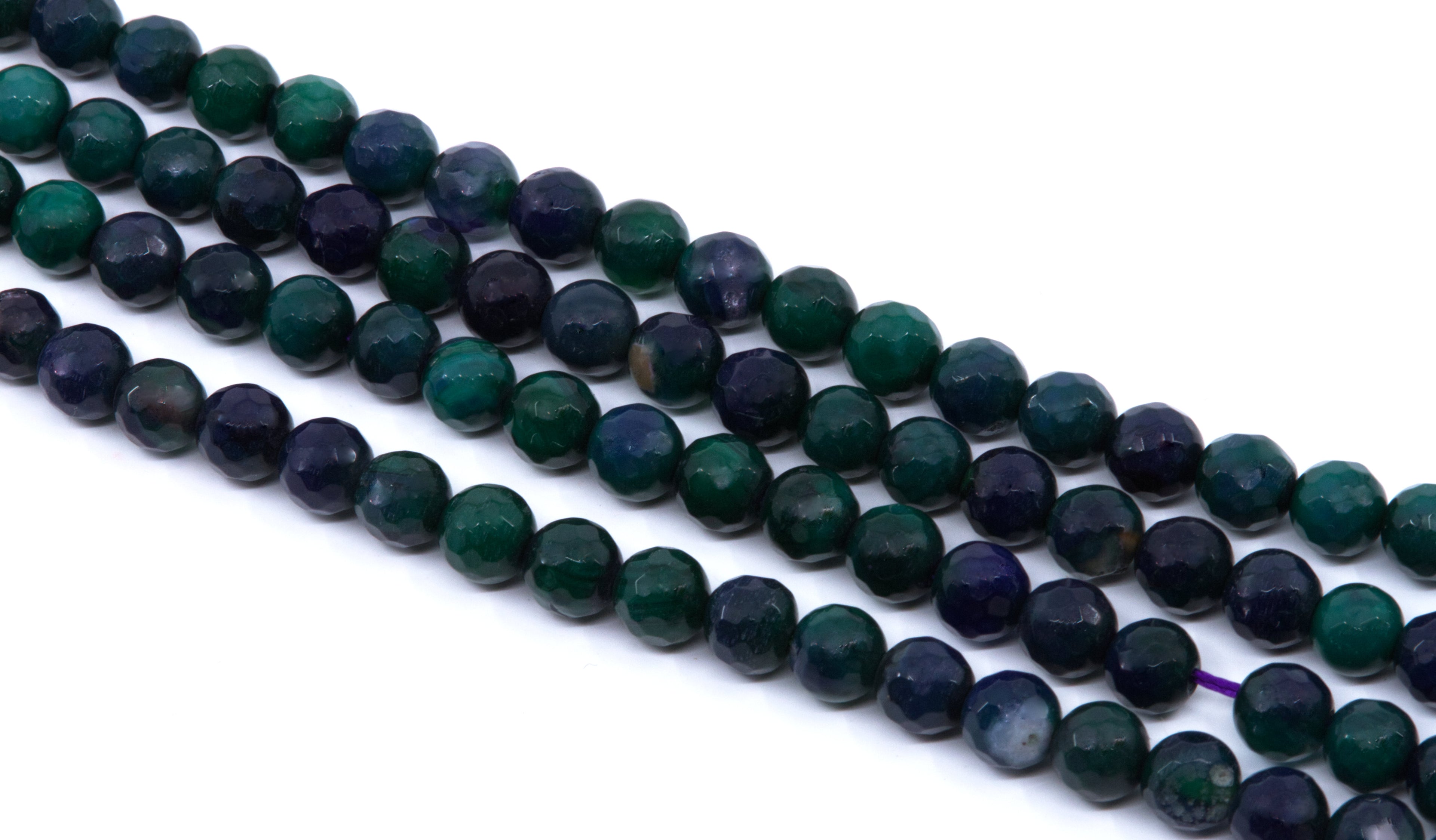 Faceted round gemstone beads in green and dark blue agate, arranged in four strands on a white background.