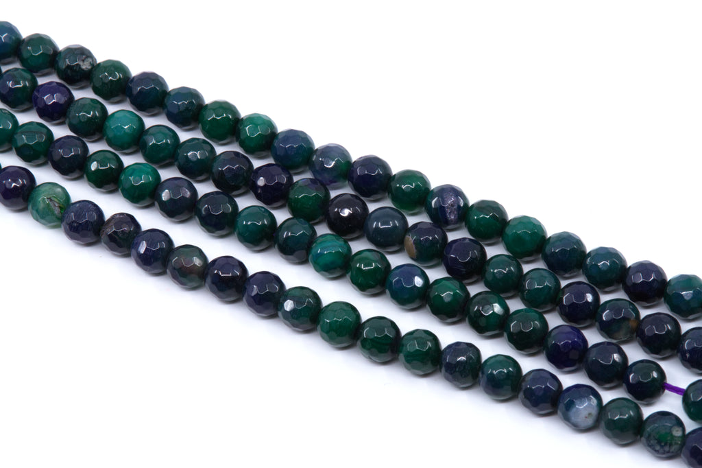 Faceted round gemstone beads in green and dark blue agate, arranged in four strands on a white background.