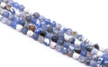 Multiple strands of faceted round agate beads in shades blue and white, arranged diagonally on a plain white background.