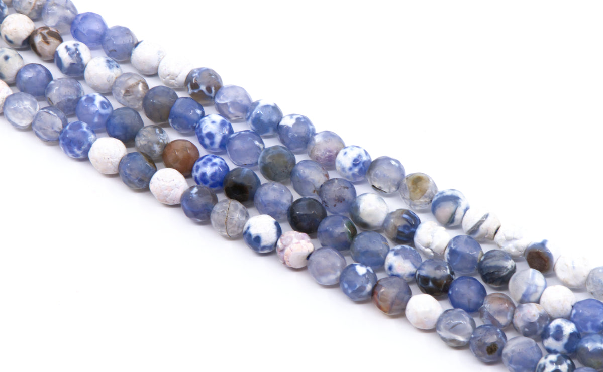 Multiple strands of faceted round agate beads in shades blue and white, arranged diagonally on a plain white background.