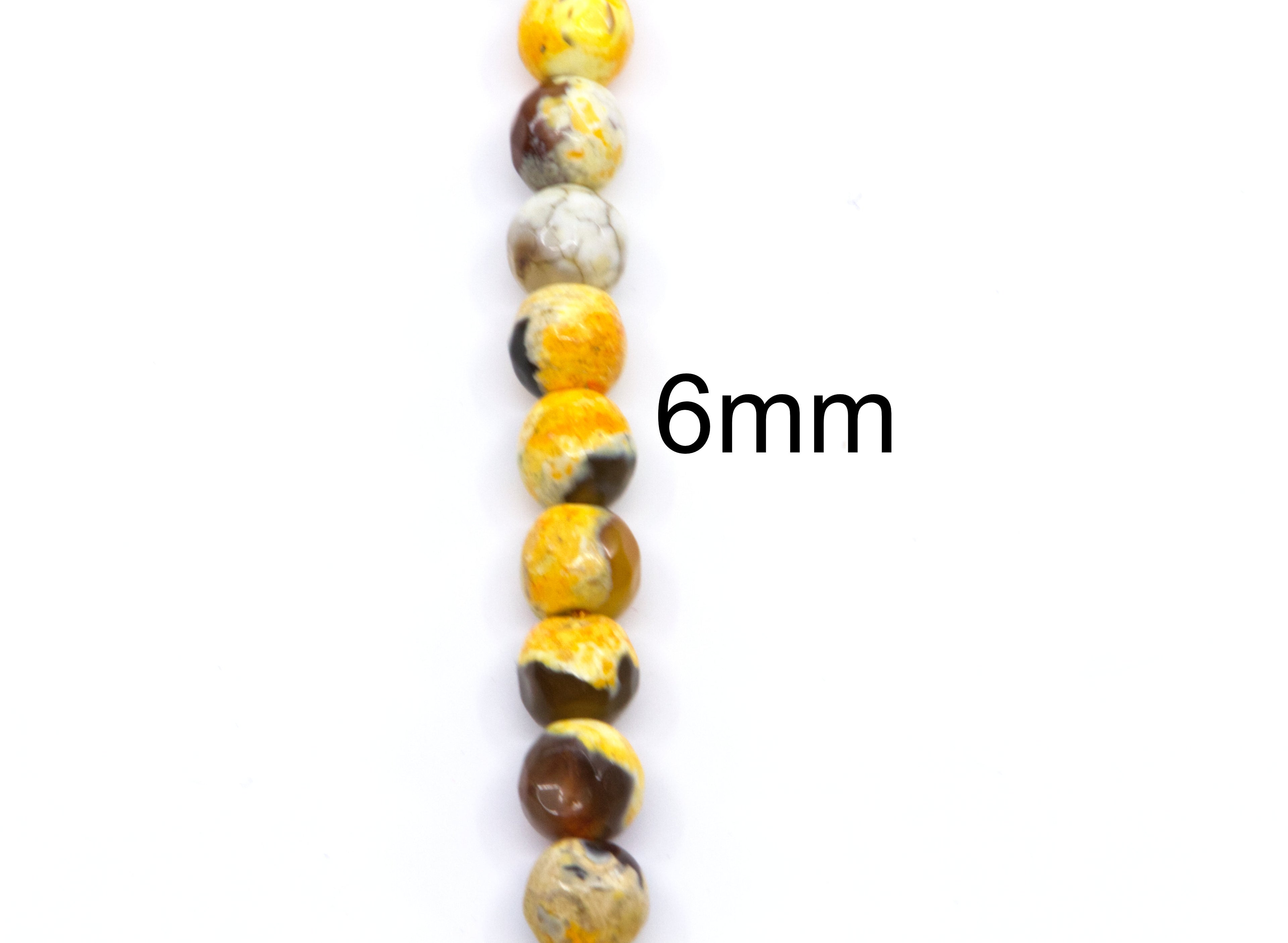 A single strand of round faceted agate beads in golden orange and black, shown vertically on a white background with a '6mm' size label.