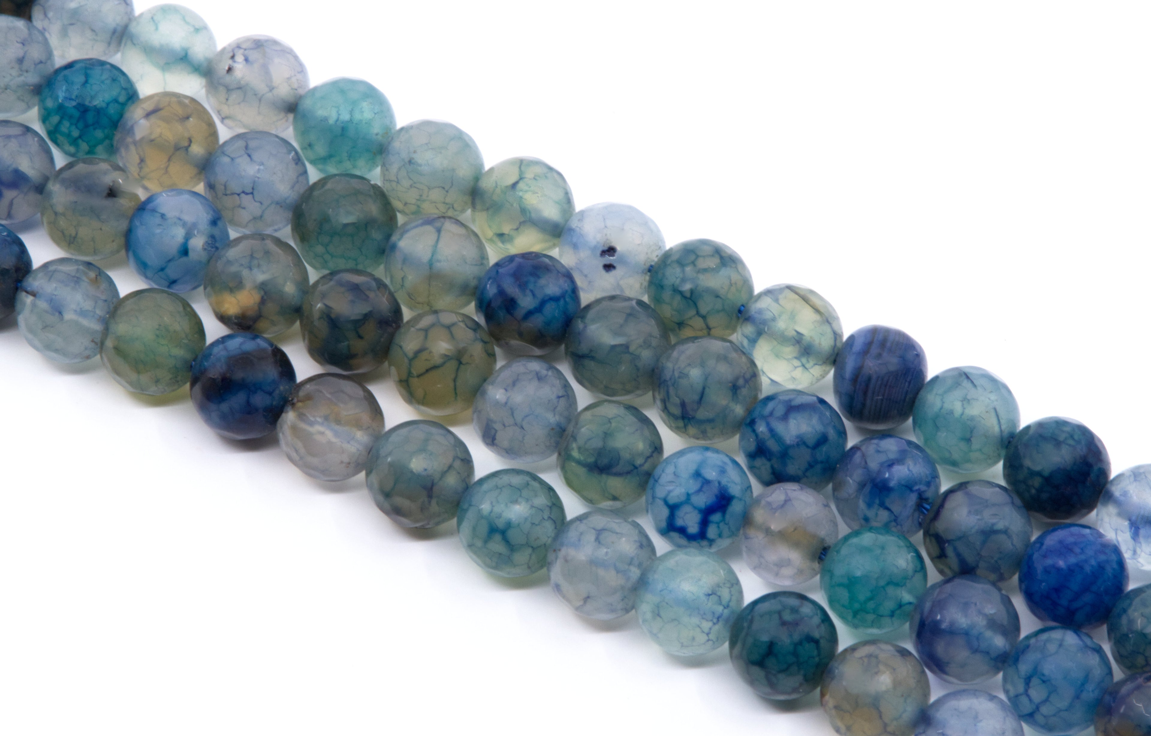 four strands of round, faceted agate beads in shades of blue, teal, green, and gray, arranged diagonally on a white background.