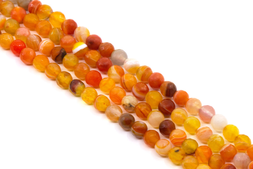 Multiple strands of round faceted agate bead charms in warm orange, yellow, red, and brown tones, arranged diagonally on a plain white background.