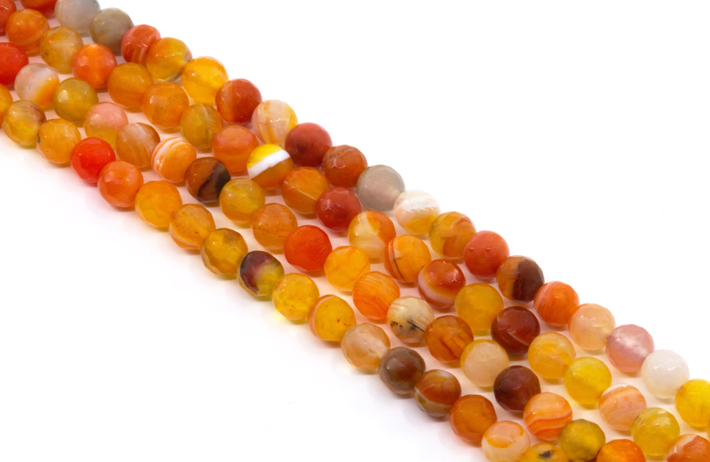 Multiple strands of round faceted agate bead charms in warm orange, yellow, red, and brown tones, arranged diagonally on a plain white background.