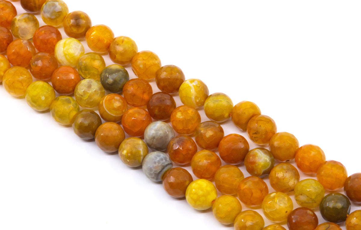 Four strands of faceted round gemstone beads in warm earthy tones, including orange, yellow and gray arranged diagonally on a white background.