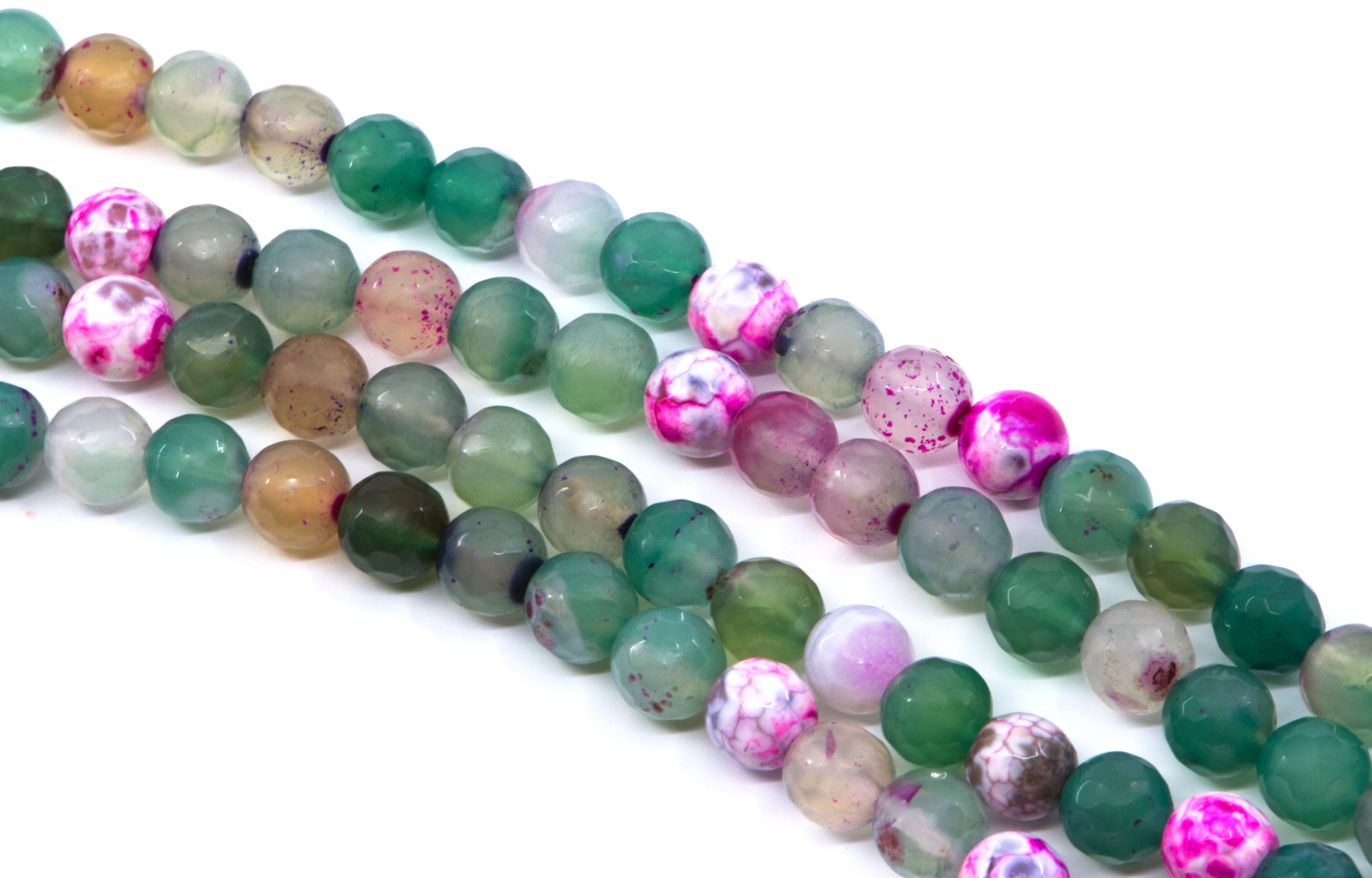 four strands of round agate beads in various colors and patterns, including green, pink, brown, and marbled designs, laid out diagonally on a white background.