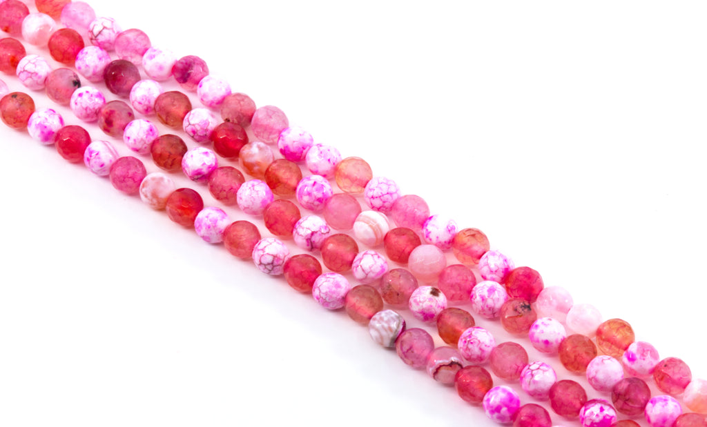 Four strands of round pink and red faceted agate beads , arranged diagonally on a white background.