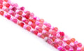 Four strands of round pink and red faceted agate beads , arranged diagonally on a white background.