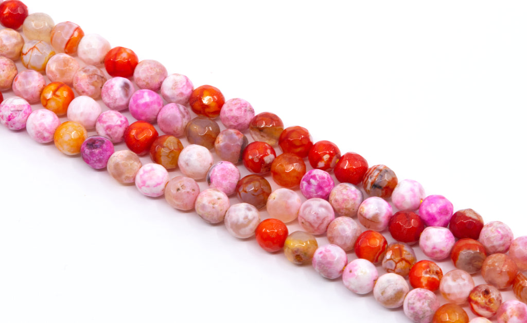 four strands of round faceted agate beads in pink, red, orange, and white , arranged diagonally on a white background.