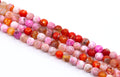 four strands of round faceted agate beads in pink, red, orange, and white , arranged diagonally on a white background.