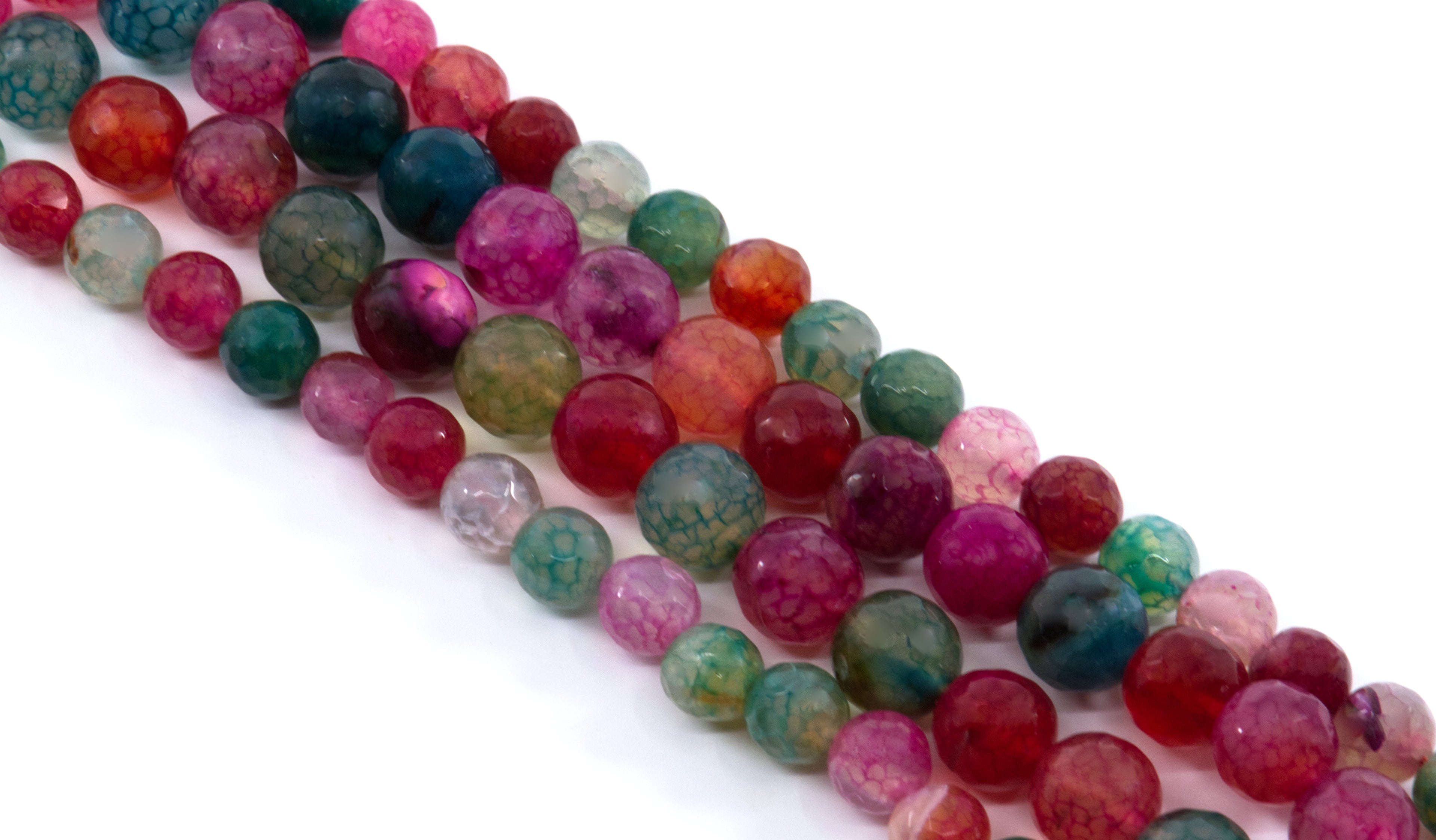 Multiple strands of faceted round gemstone beads in assorted colors, including pink, red and green arranged diagonally on a white background.