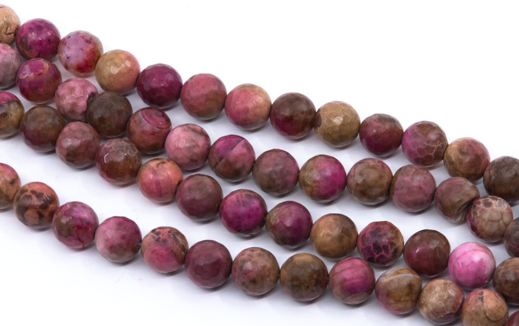 Multiple strands of polished round faceted agate beads in pinkish-red and brown , arranged diagonally on a white background.