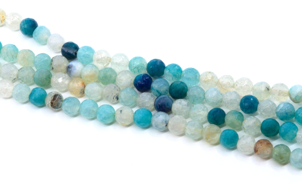 Faceted round agate beads in shades of blue, arranged in diagonal strands on a white background.