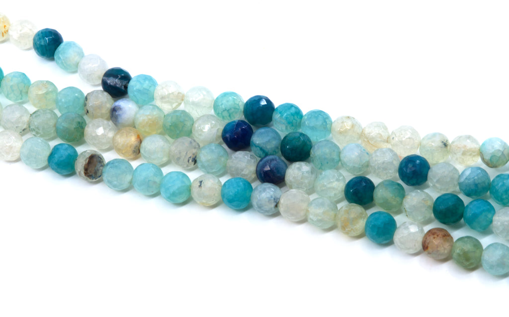 Faceted round agate beads in shades of blue, arranged in diagonal strands on a white background.