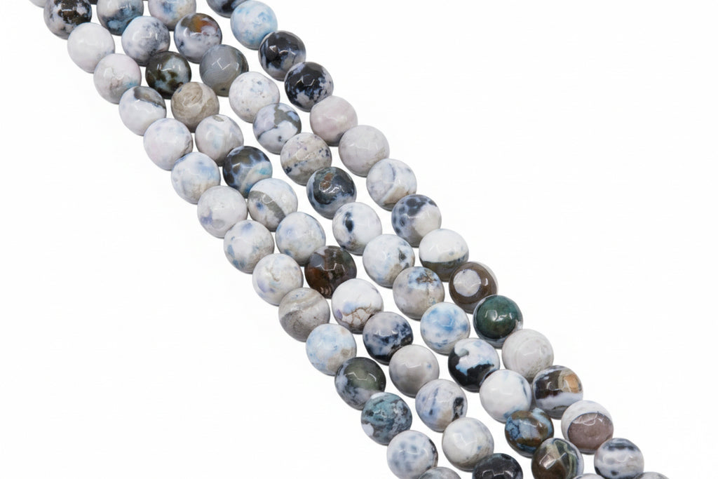 Four strands of round faceted agate beads with marbled patterns in white, gray, and blue,  arranged diagonally on a solid gray background.