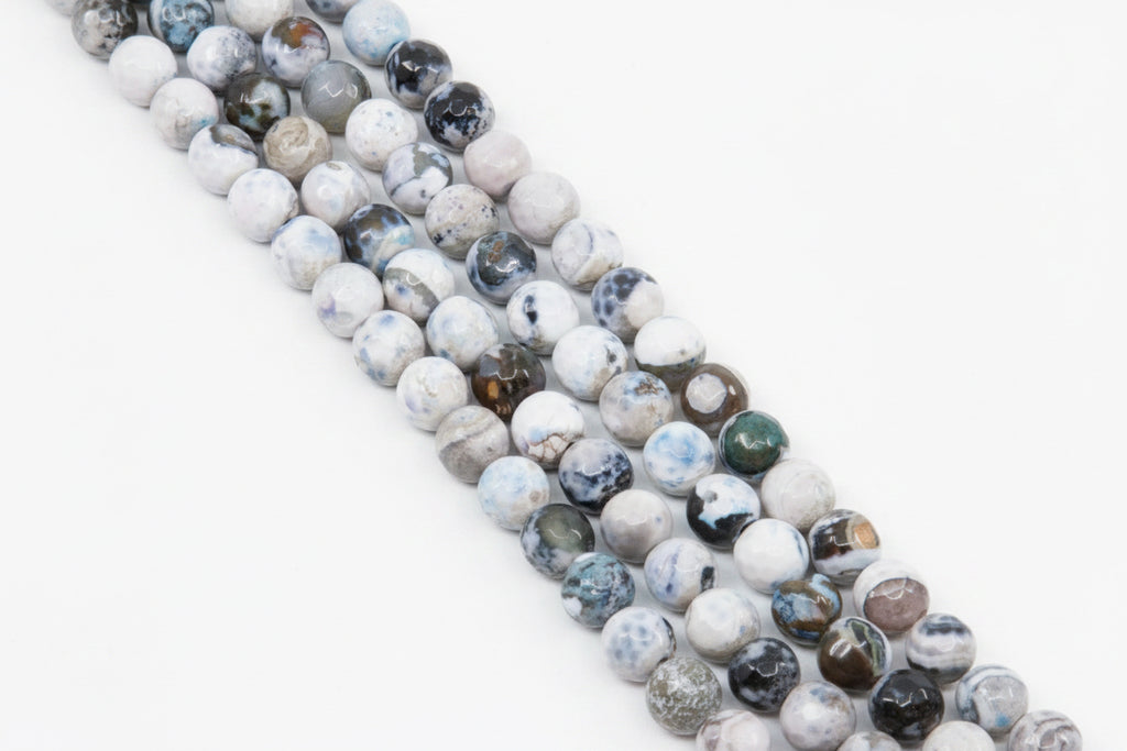 Four strands of round faceted agate beads with marbled patterns in white, gray, and blue,  arranged diagonally on a solid gray background.