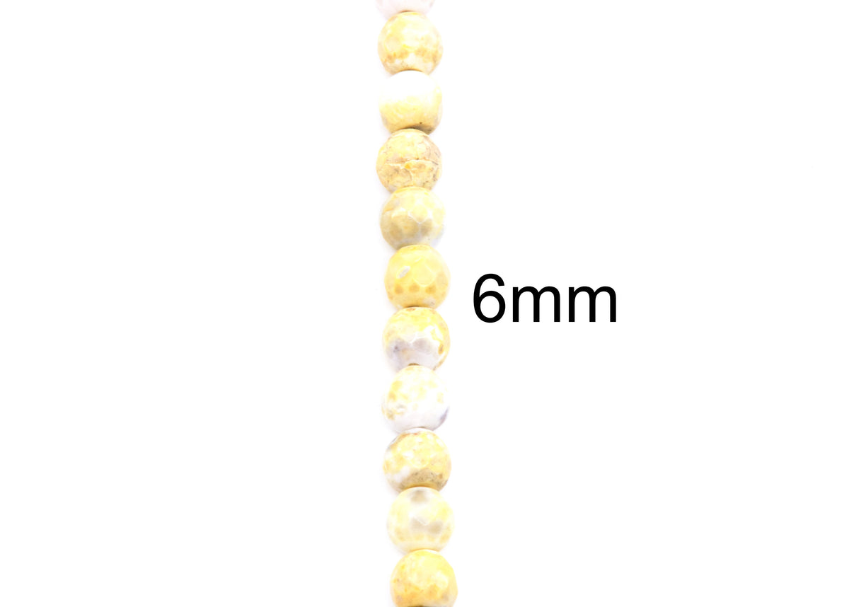 A vertical strand of round, faceted yellow and white beads with a black '6mm' text overlay on a plain white background.