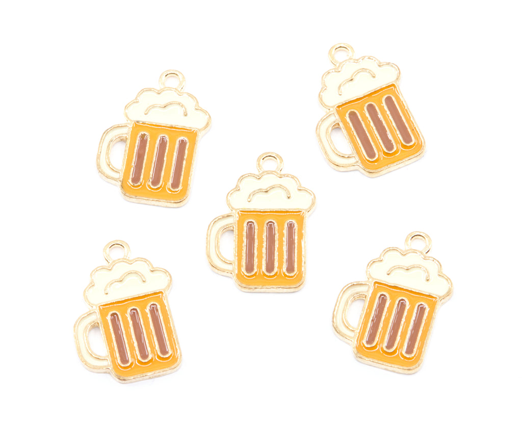 Five small beer mug charms with gold-tone metal outlines and orange enamel, each topped with cream-colored foam, arranged on a plain white background.