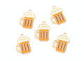 Five small beer mug charms with gold-tone metal outlines and orange enamel, each topped with cream-colored foam, arranged on a plain white background.