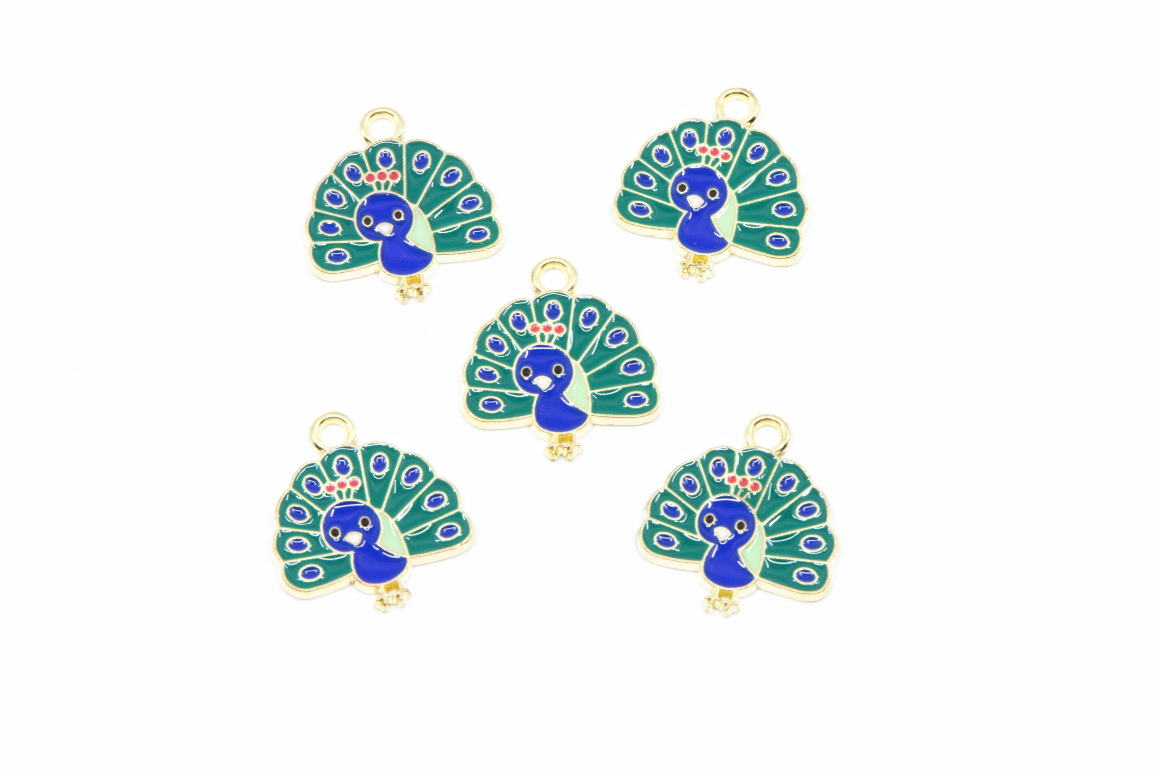 Five peacock-shaped jewelry charms with gold-tone metal borders and loops, featuring blue and green enamel detailing on a white background.