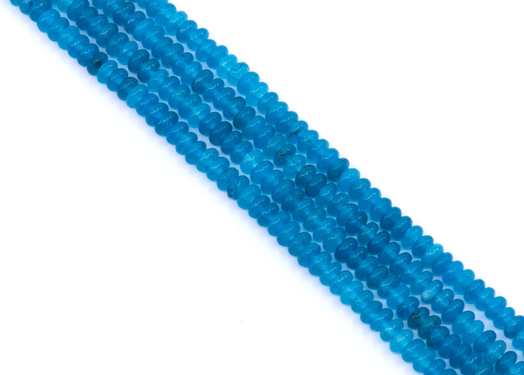 Multiple strands of small, rondelle dyed blue jade beads arranged diagonally on a plain white background.