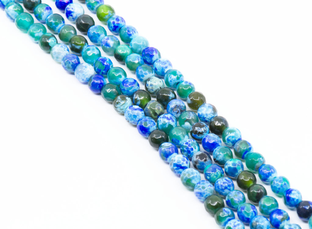 Four strands of round faceted agate beads in shades of blue and green with marbled and swirled patterns, arranged diagonally on a white background.