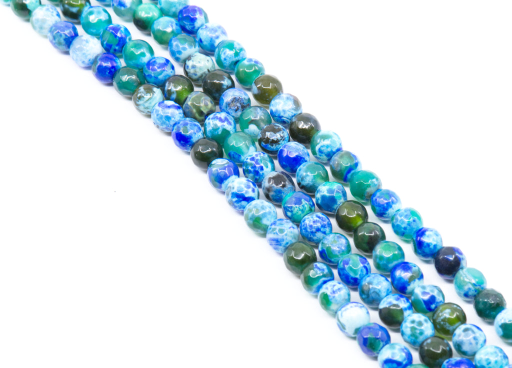 Four strands of round faceted agate beads in shades of blue and green with marbled and swirled patterns, arranged diagonally on a white background.