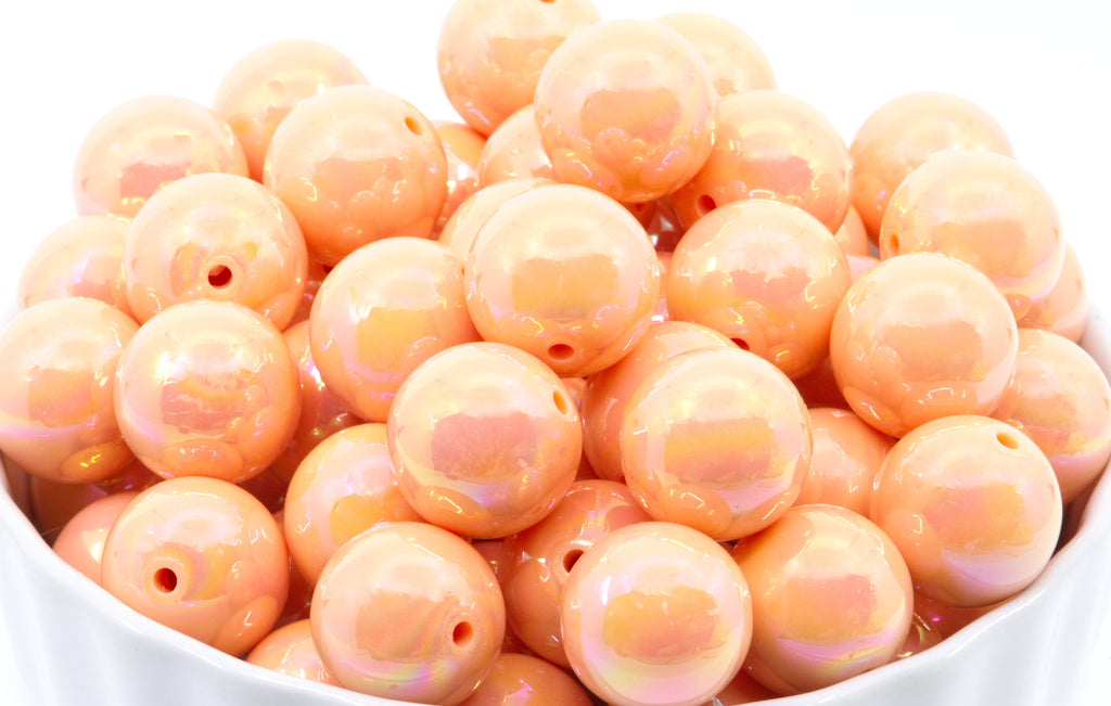 orang iridescent beads in a white bowl on a white background