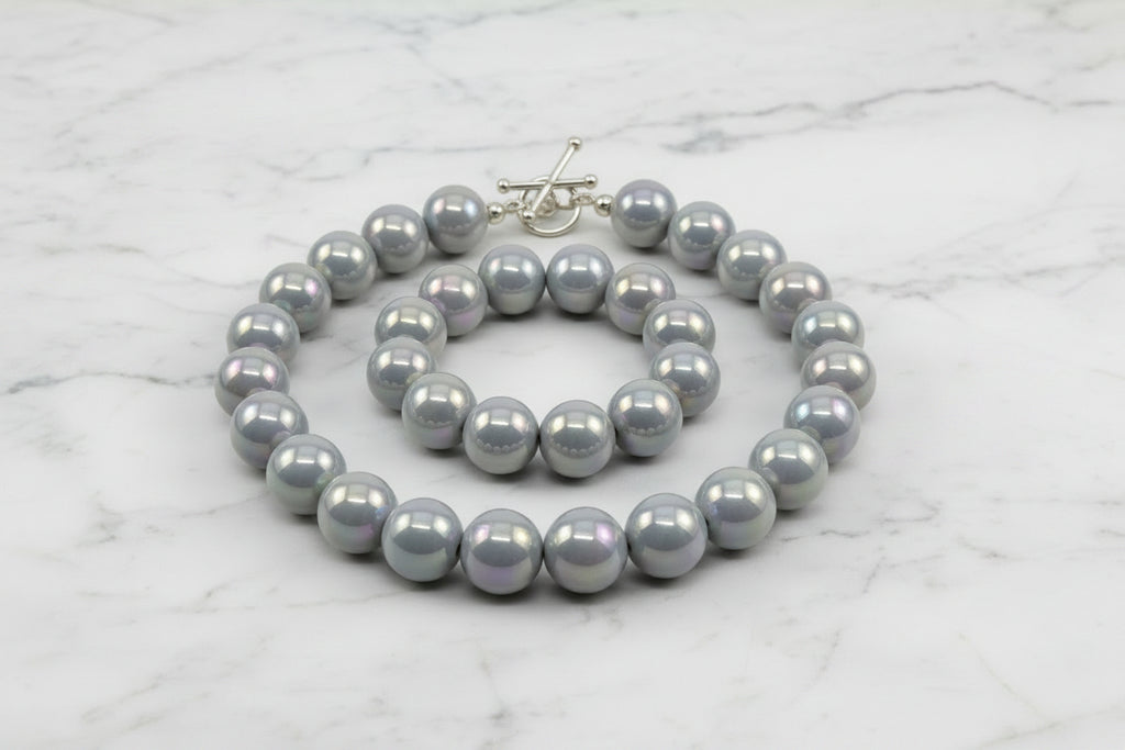 gray iridescent round beads displayed as a necklace on a white background