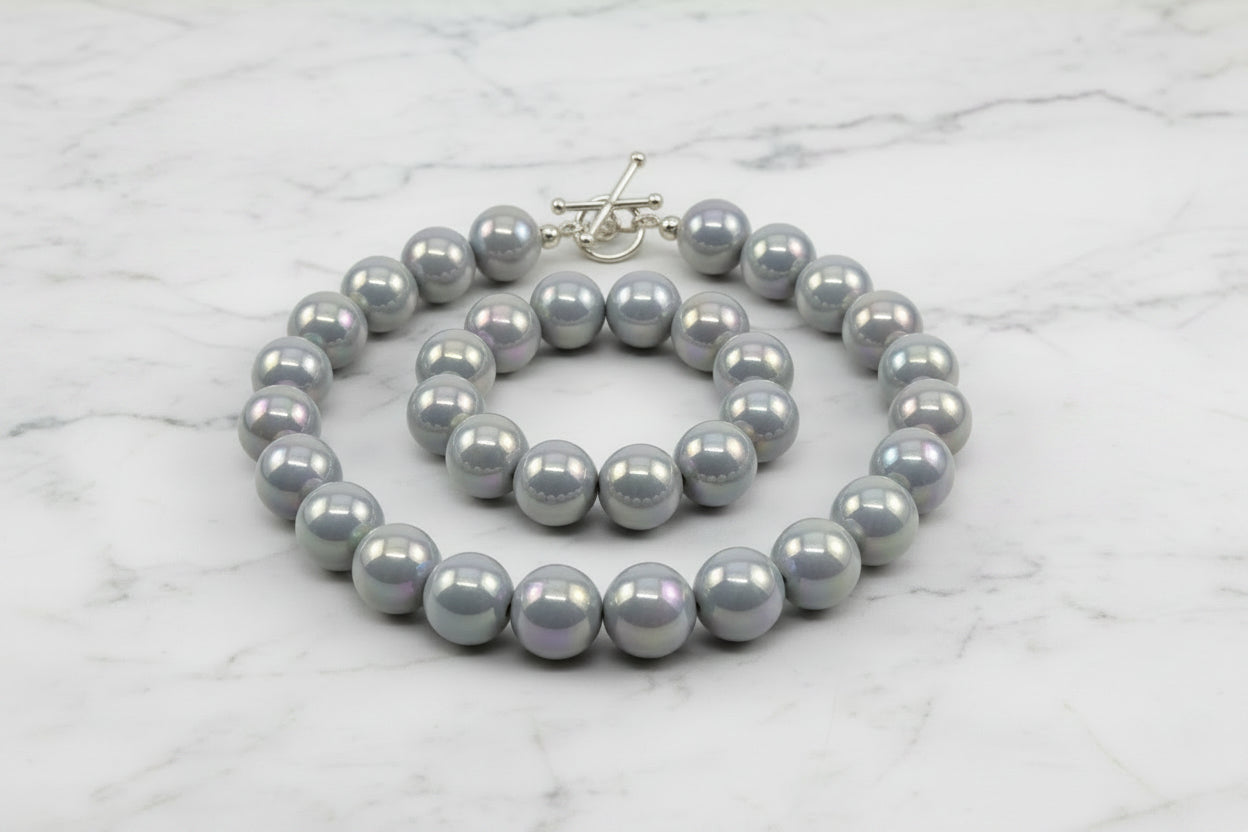 gray iridescent round beads displayed as a necklace on a white background