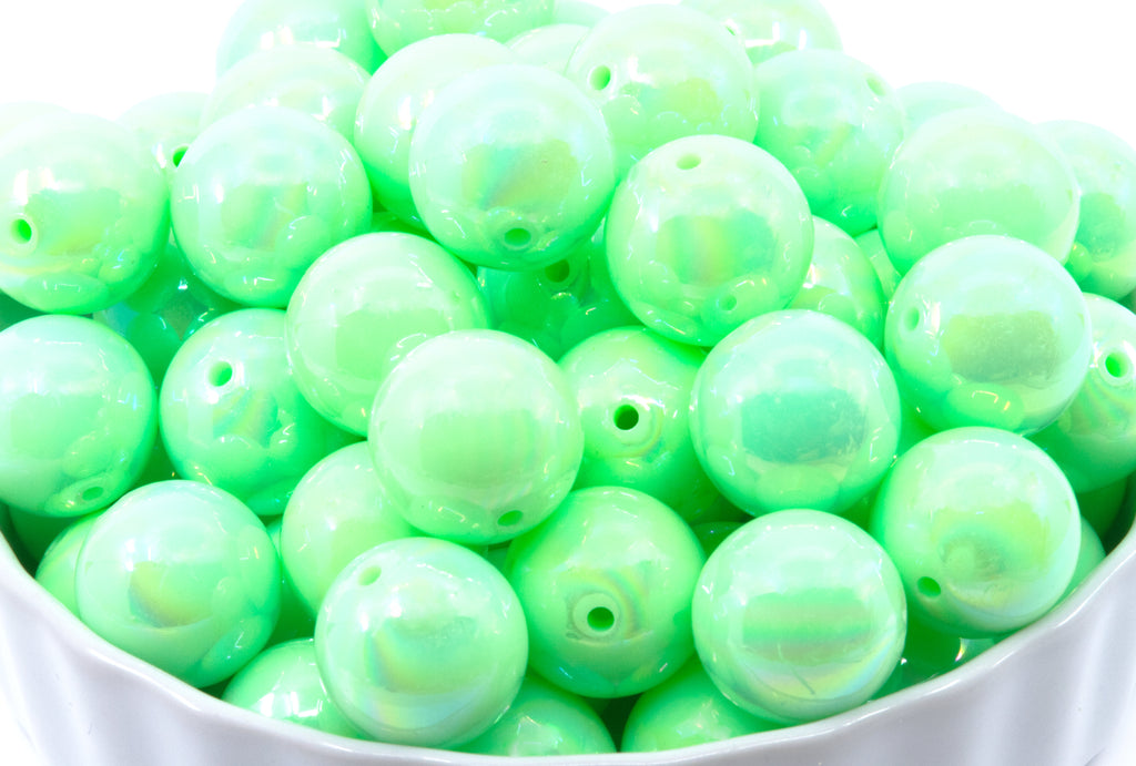 green iridescent bubblegum beads in a white bowl