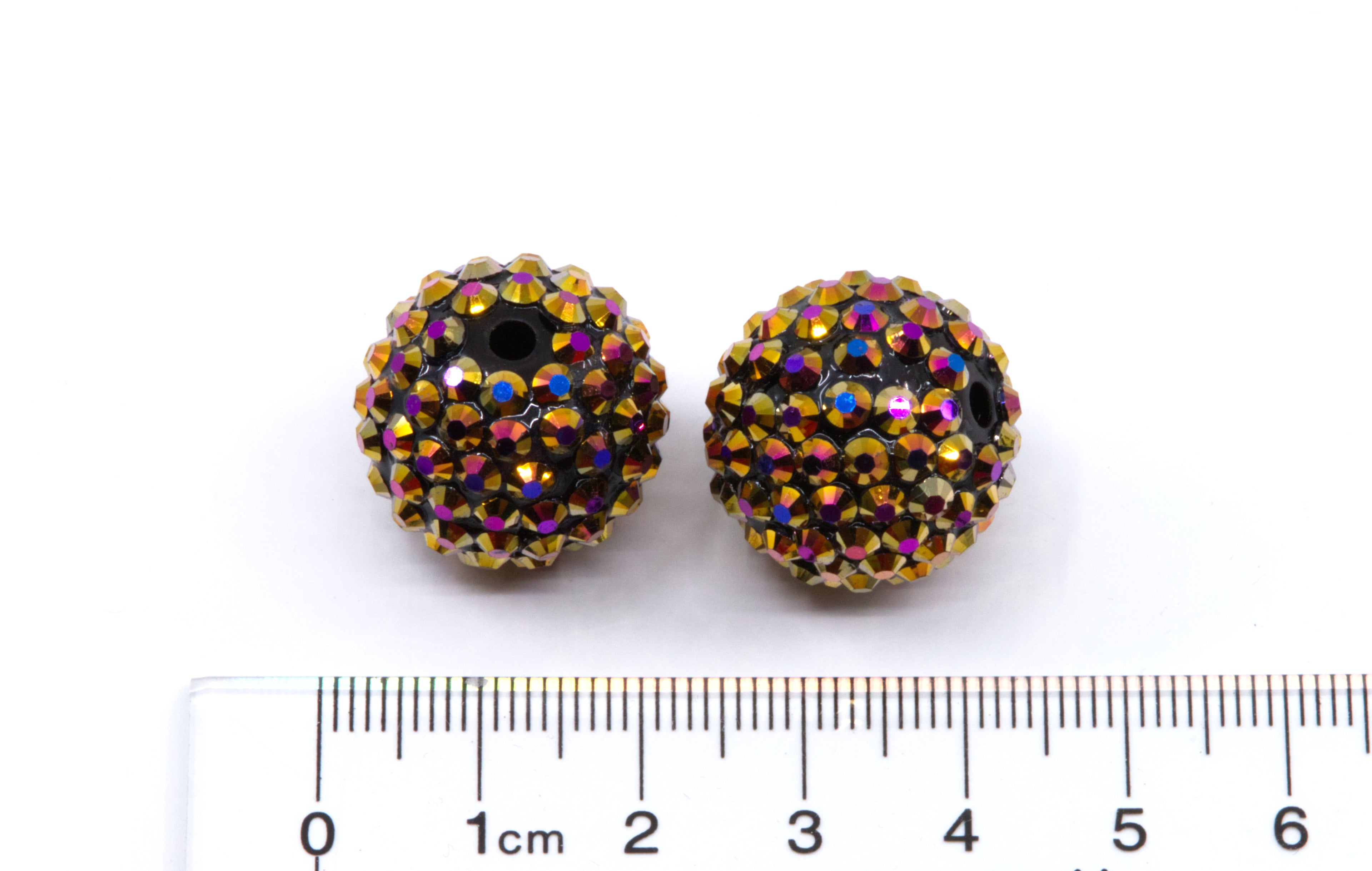 Two round gold AB rhinestone bubblegum beads, shown above a cm ruler for scale on a white background.
