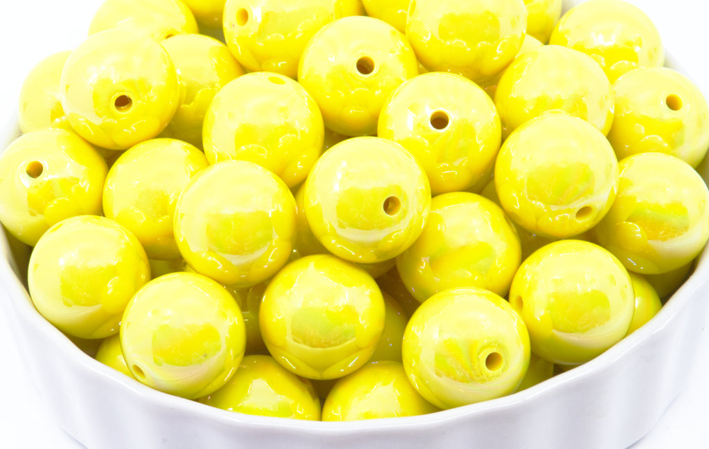Yellow iridescent beads in a white bowl