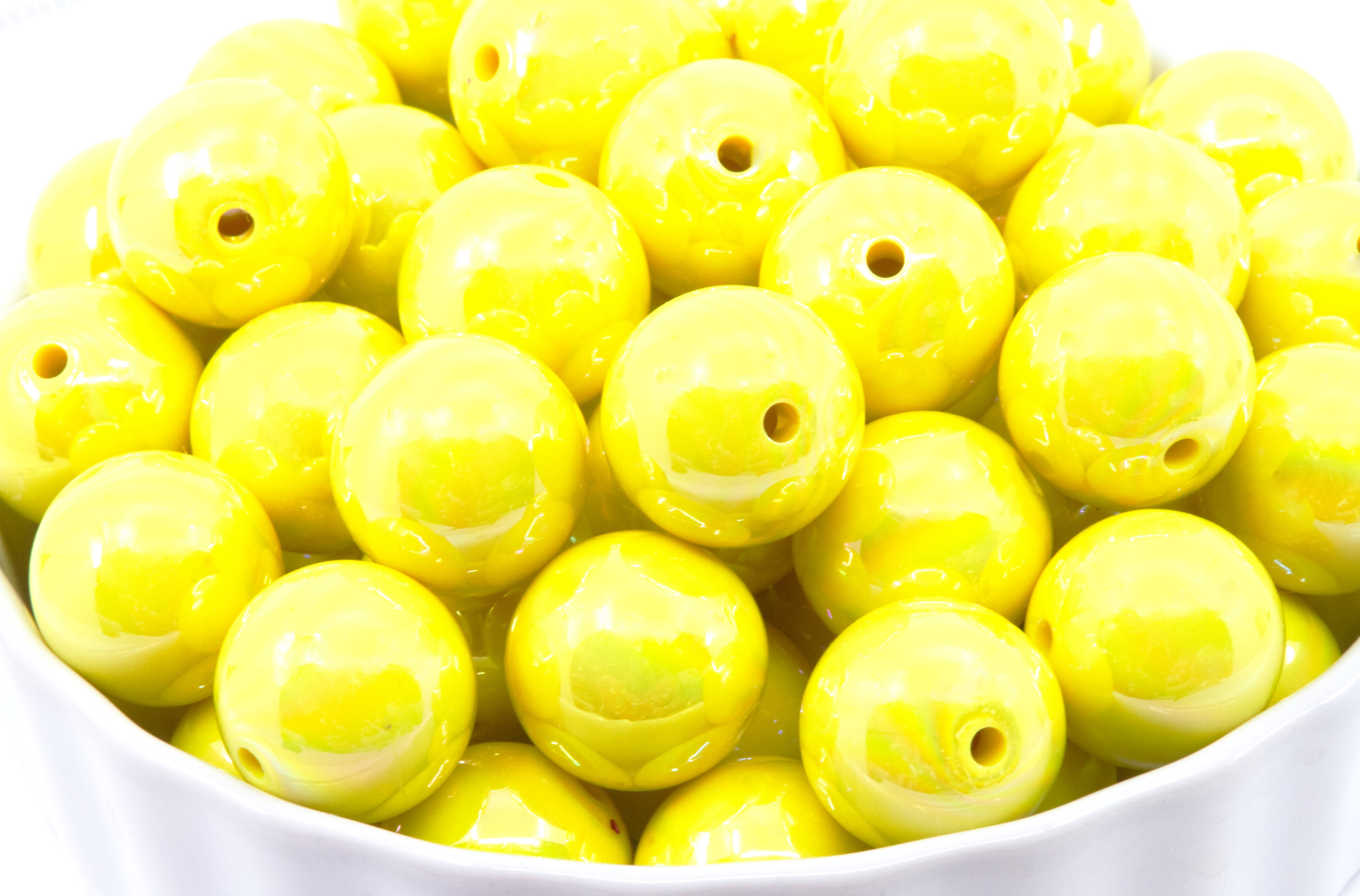 Yellow iridescent beads in a white bowl