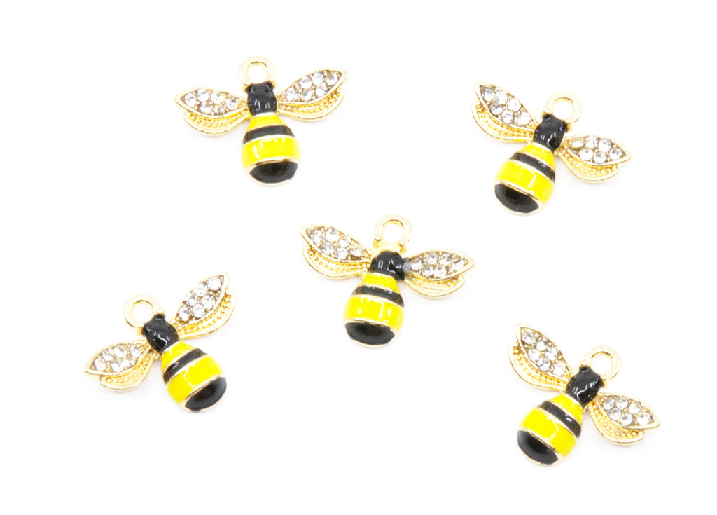 Five gold bumblebee charms with yellow and black striped bodies and clear rhinestone wings, arranged on a plain white background.