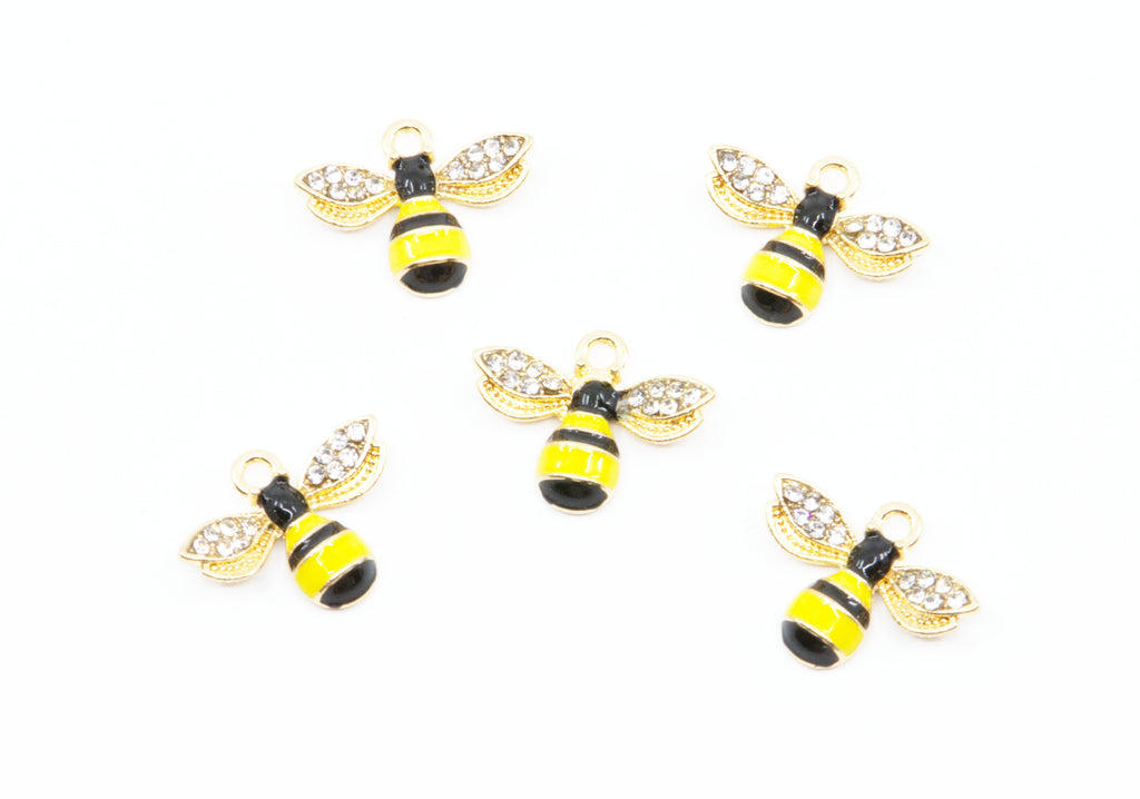Five gold bumblebee charms with yellow and black striped bodies and clear rhinestone wings, arranged on a plain white background.