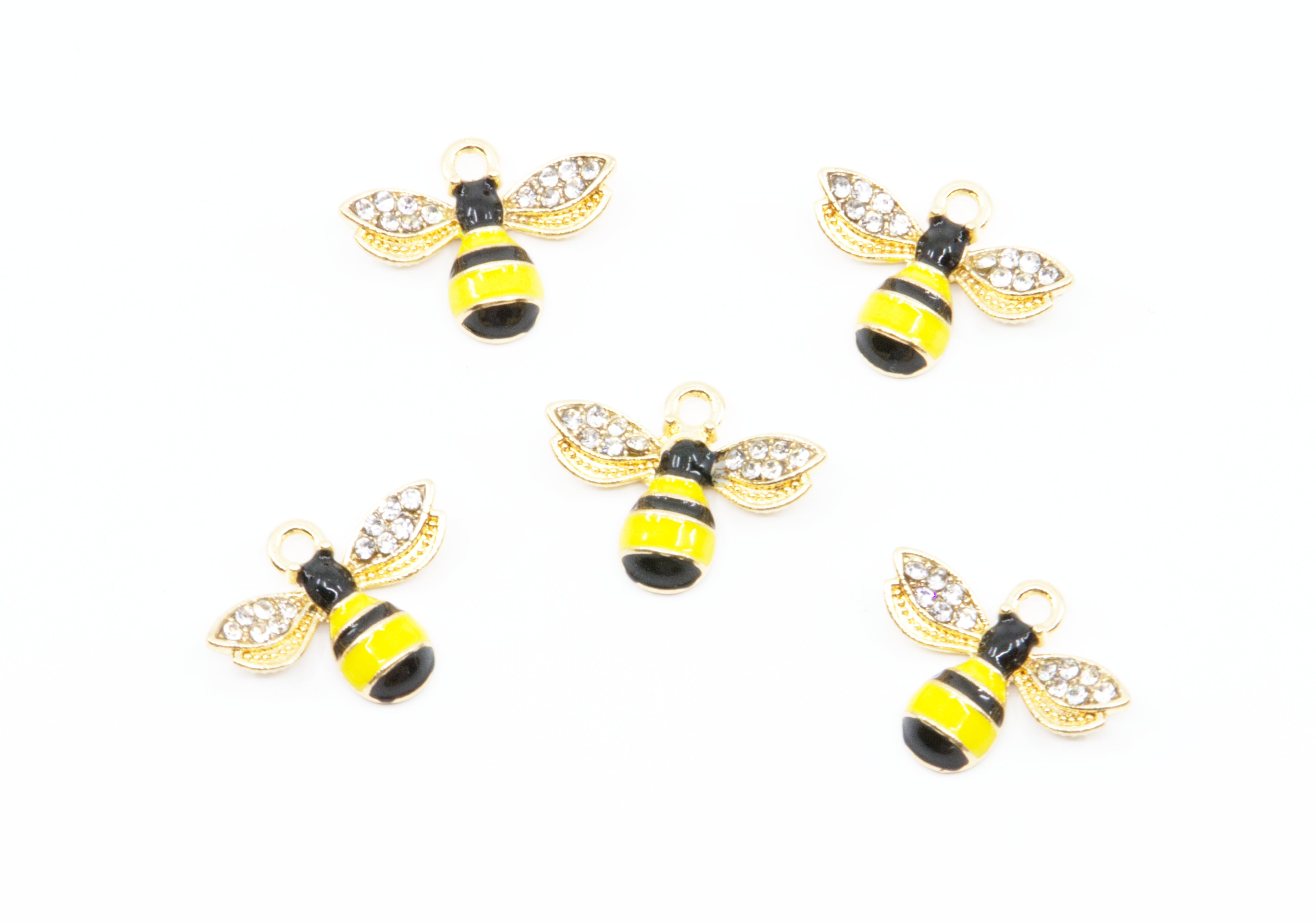 Five gold bumblebee charms with yellow and black striped bodies and clear rhinestone wings, arranged on a plain white background.