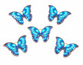 Five butterfly-shaped jewelry charms with vibrant blue and light blue patterned wings and gold-tone metal edges, arranged on a plain white background.