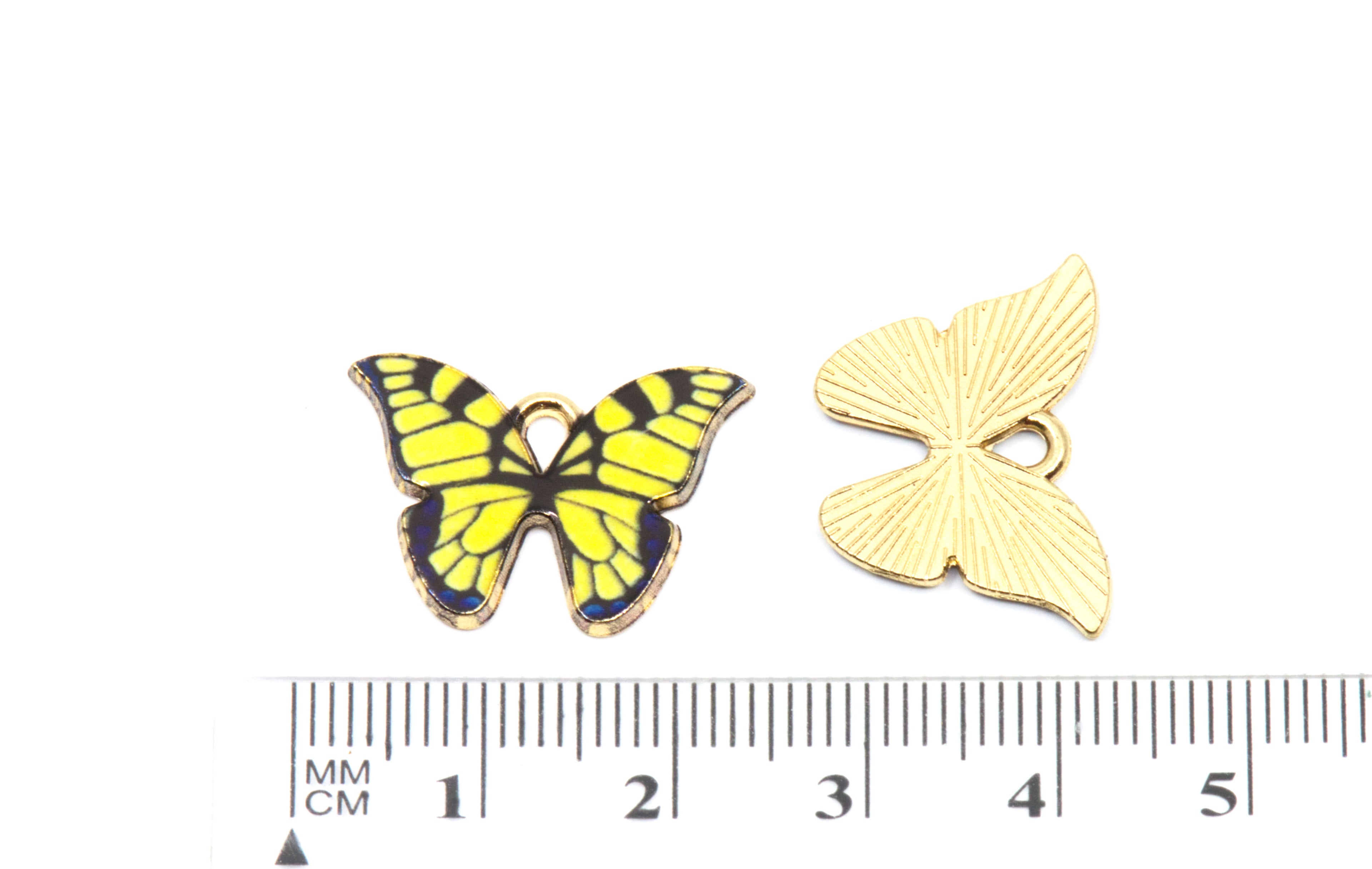 Two butterfly-shaped jewelry charms shown on a white background with a ruler at the bottom for scale. 