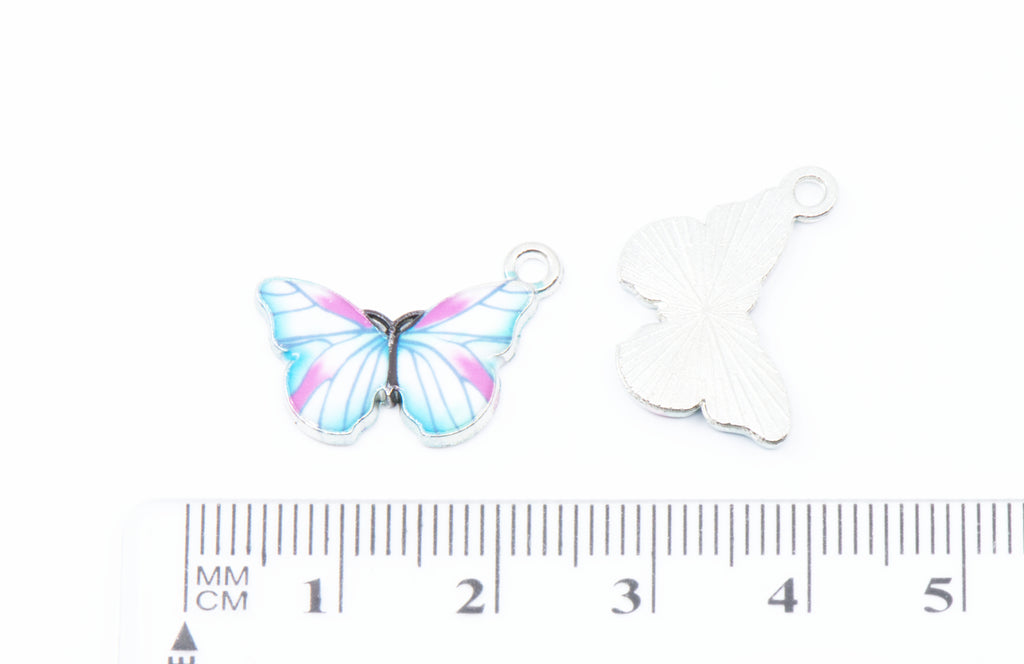 Two butterfly-shaped jewelry charms on a white background. A small ruler is shown below for scale.