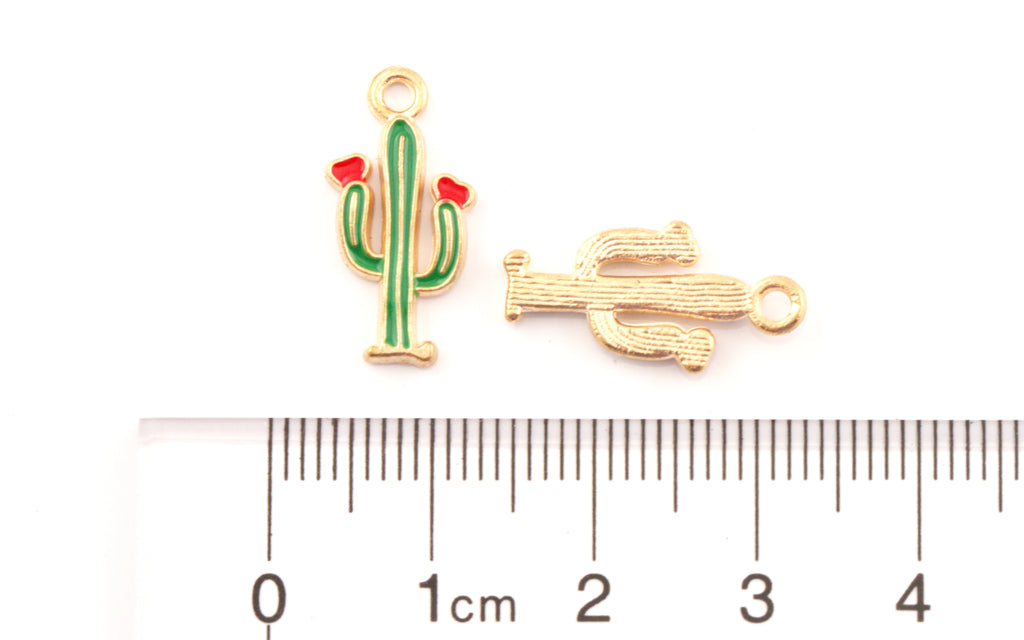 Two small cactus-shaped jewelry findings or charms shown above a ruler for scale on a white background. 