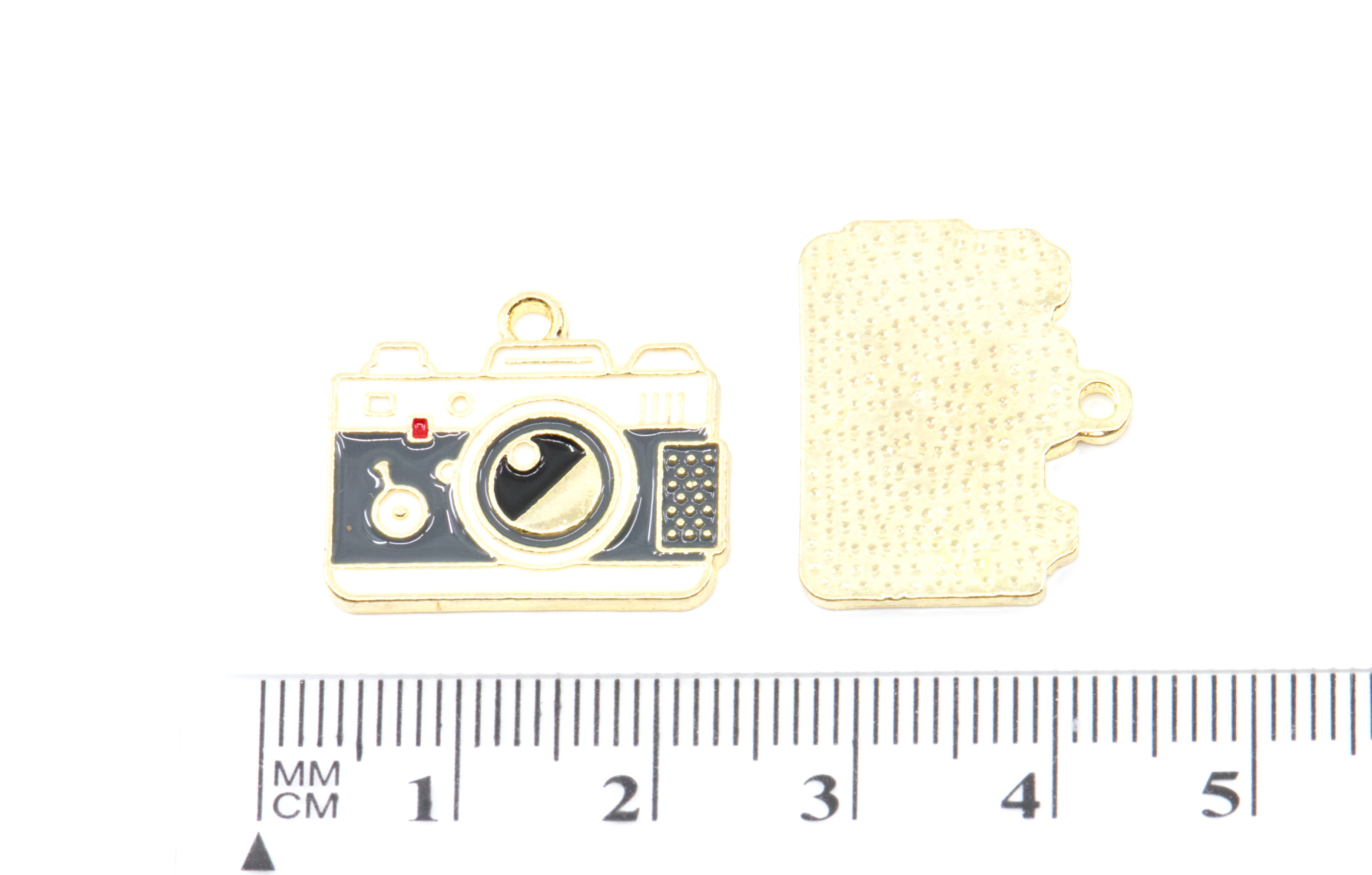 Two gray and white enamel camera charms shown above a ruler for scale on a white background. 