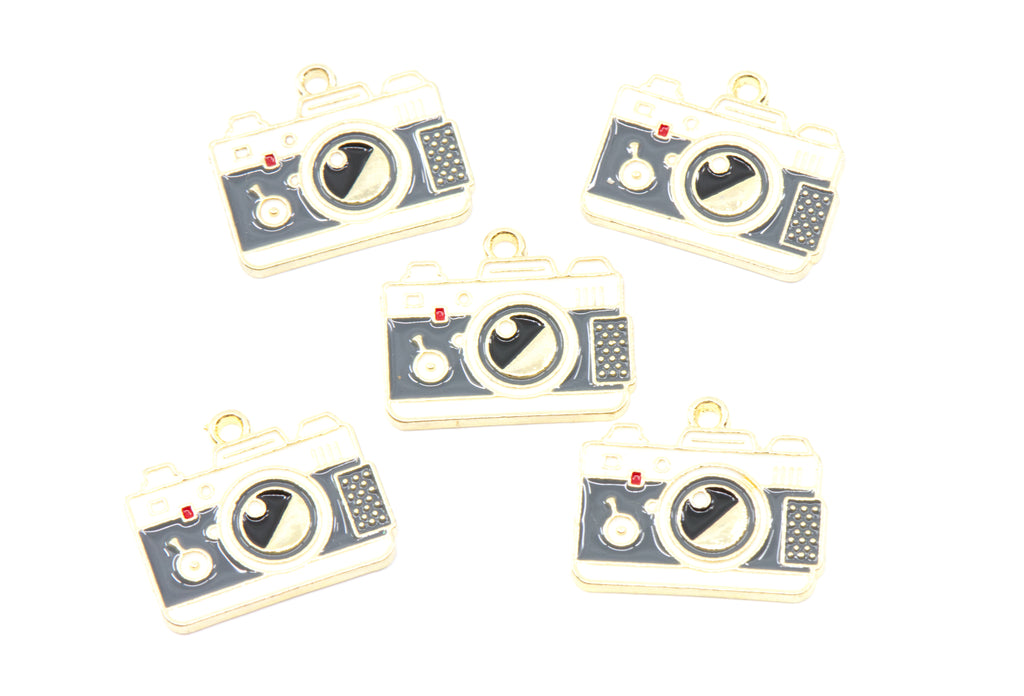 Five camera-shaped jewelry charms with gold-tone metal borders and dark gray enamel details, arranged on a plain white background.