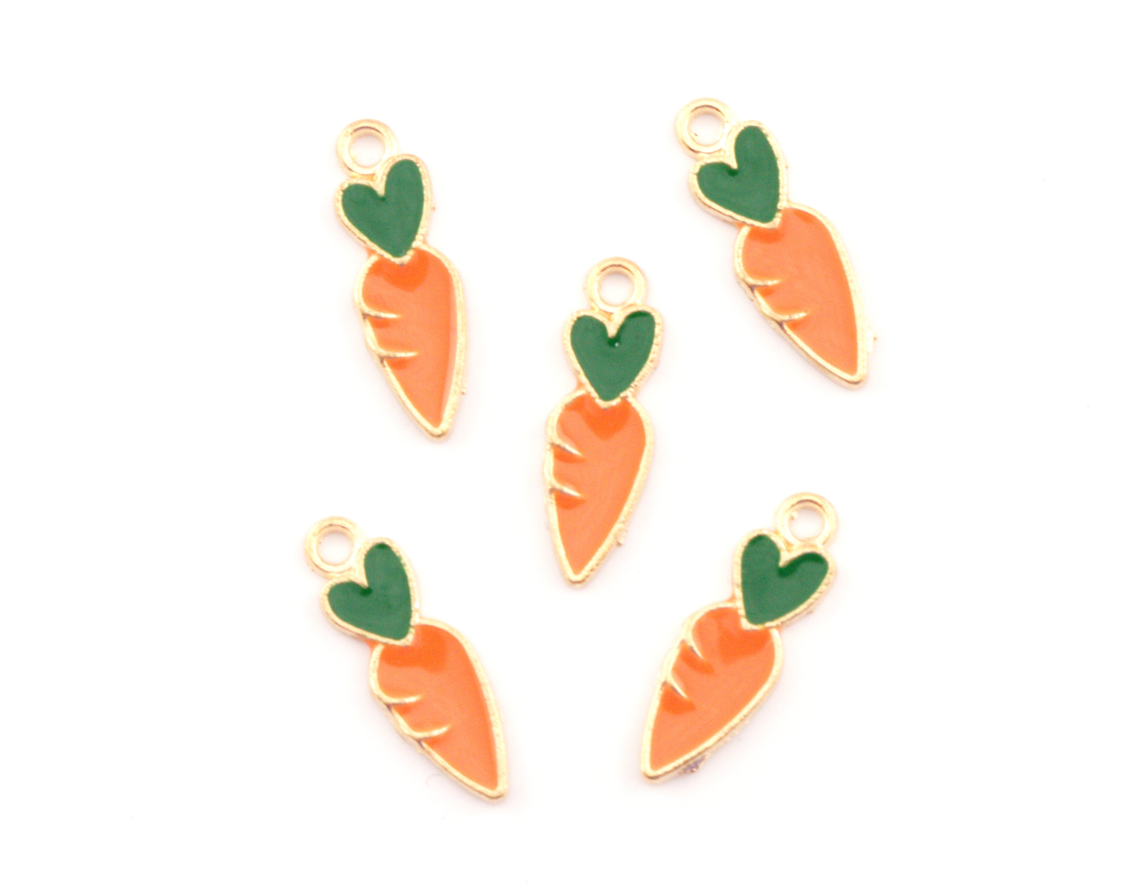 Five carrot-shaped jewelry charms with gold-plated edges, orange enamel bodies, and green enamel tops, arranged on a plain white background.
