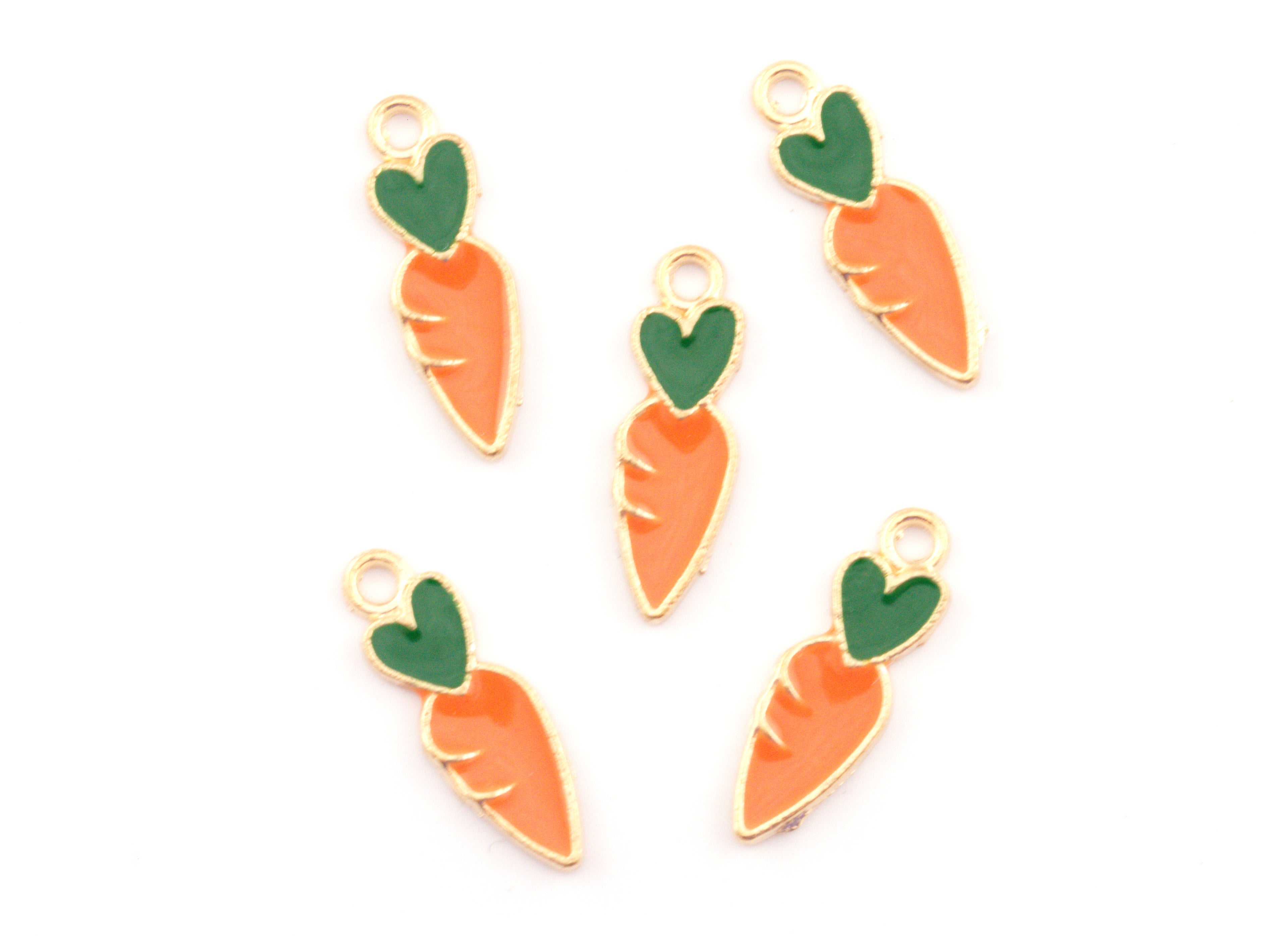 Five carrot-shaped jewelry charms with gold-plated edges, orange enamel bodies, and green enamel tops, arranged on a plain white background.