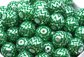 A close-up of many green and silver chevron-patterned round beads filling the frame.