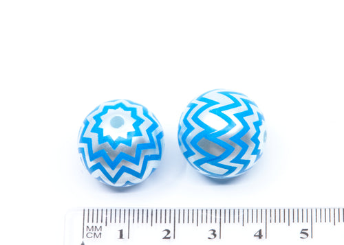 Two round glass acrylic with blue and silver chevron patterns, shown next to a cm ruler for scale on a white background.