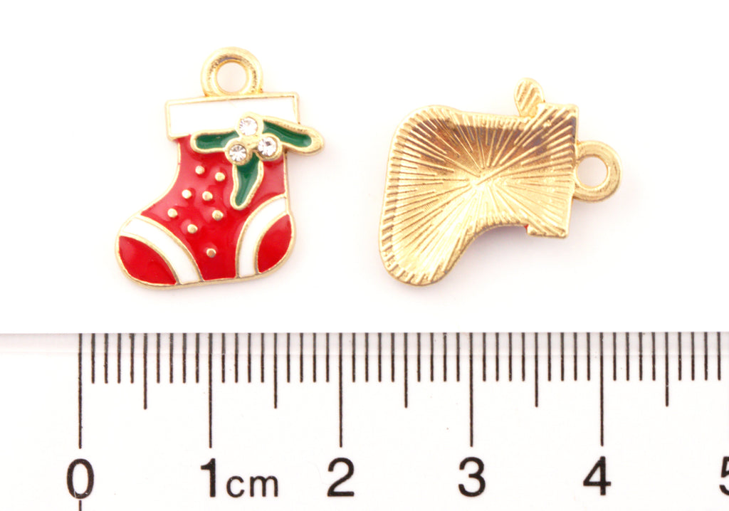 Two small Christmas stocking charms shown on a white background with a ruler below for scale. 