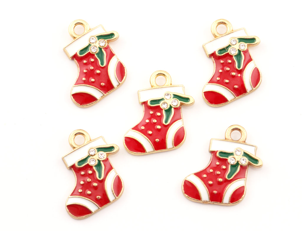 Five Christmas stocking charms with red enamel, white trim, green holly leaves, and gold-tone metal borders on a plain white background.
