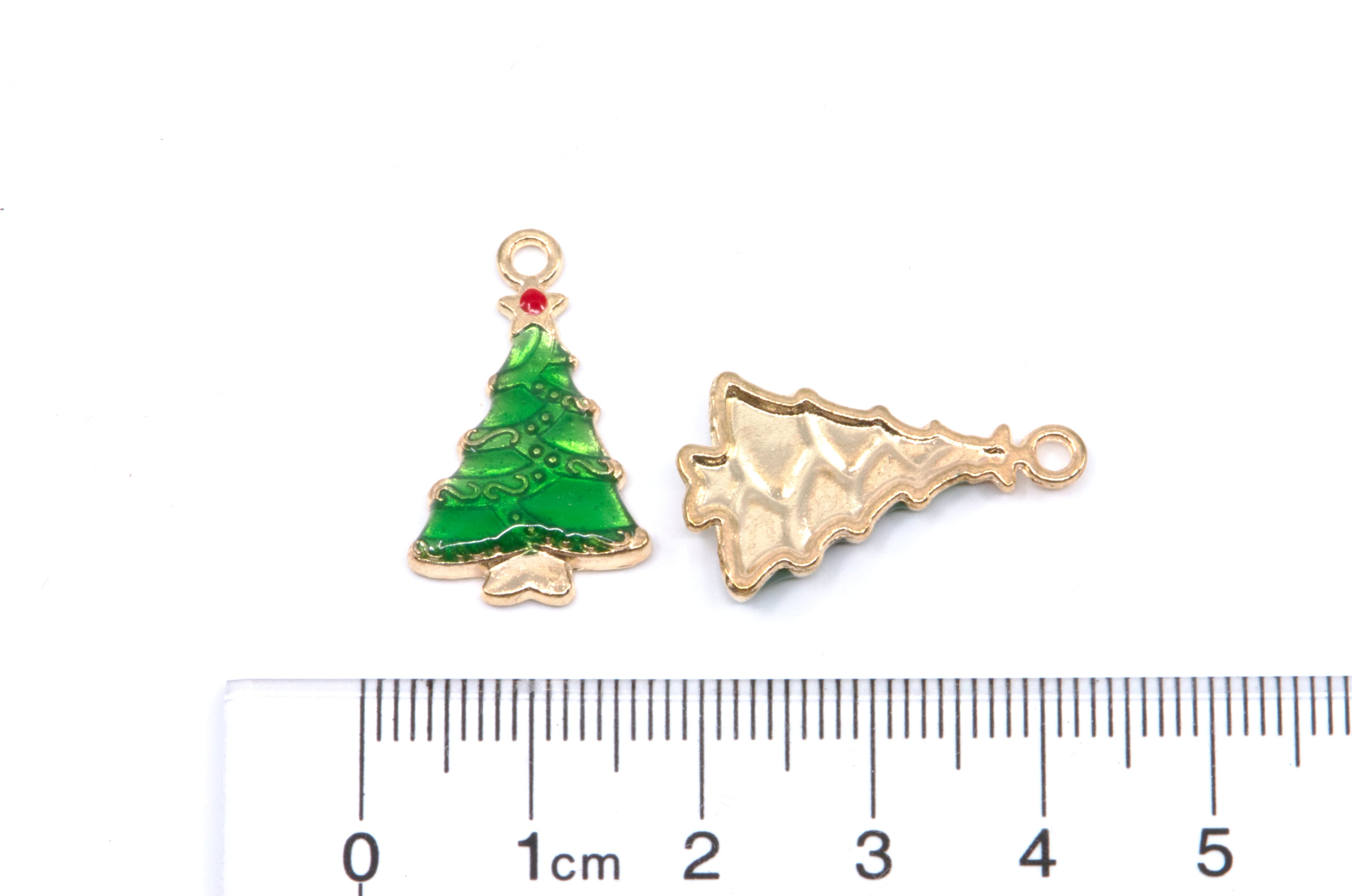 Two Christmas tree-shaped jewelry charms shown on a white background with a ruler at the bottom for scale. 